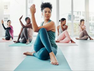 Fitness, yoga class and stretching exercise with women together for health and wellness. Instructor
