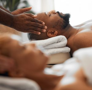 Relax man, head massage and couple on spa massage table for facial, wellness and stress relief ther