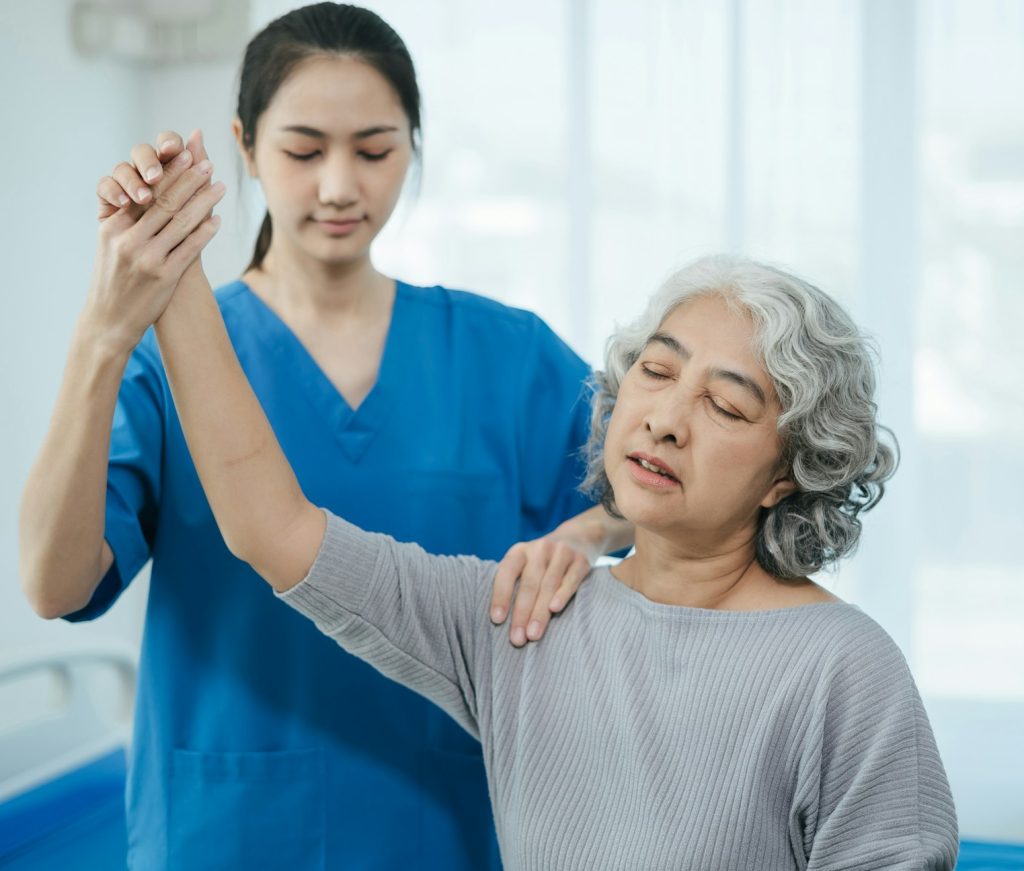 senior woman doing exercise at clinic with physiotherapist.